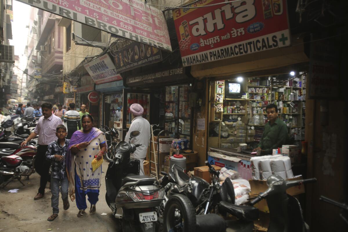 People walk past drugstores where tramadol was once easily accessible in Amritsar, in the northern Indian state of Punjab.