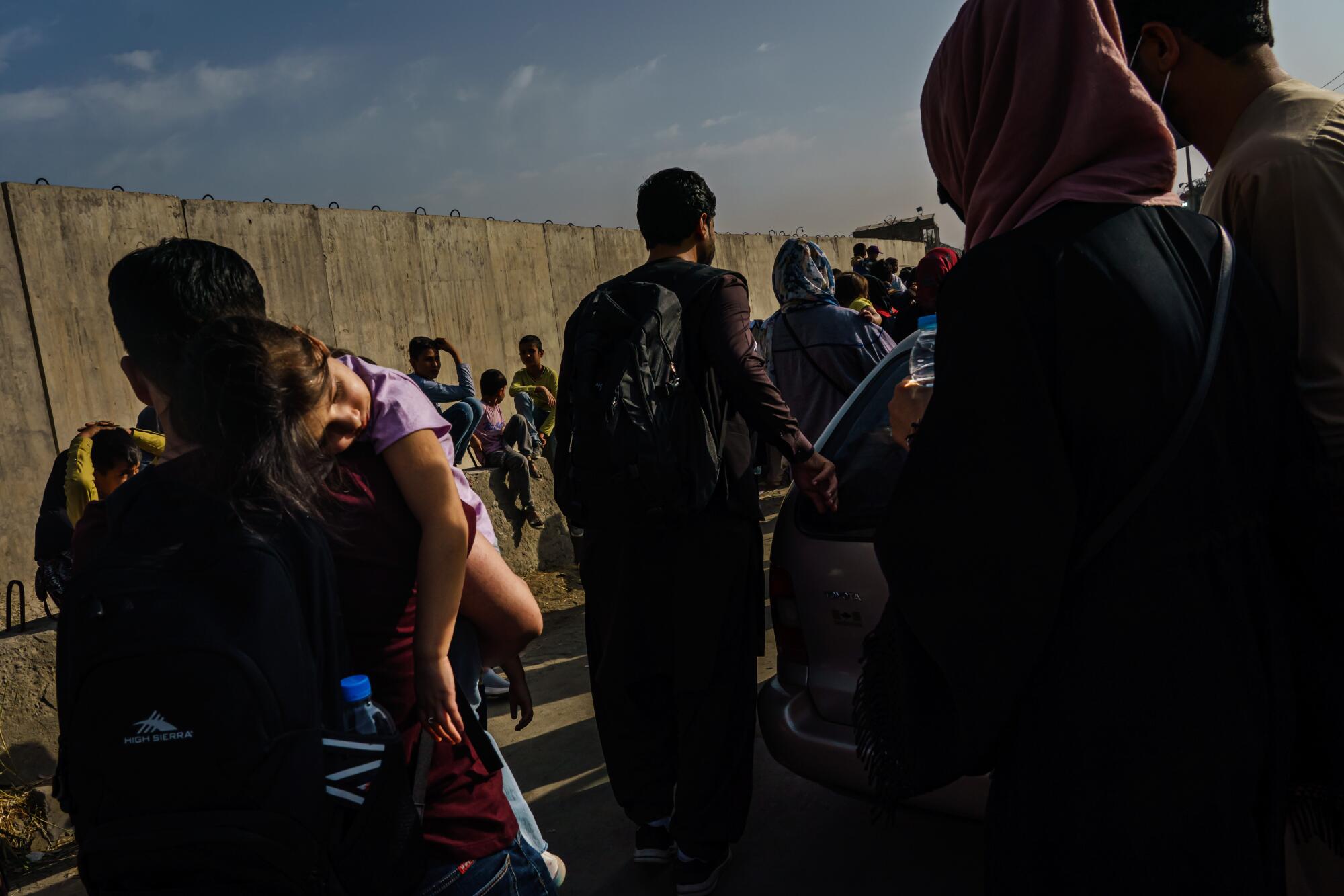 A crowd of people gather, facing away from the camera