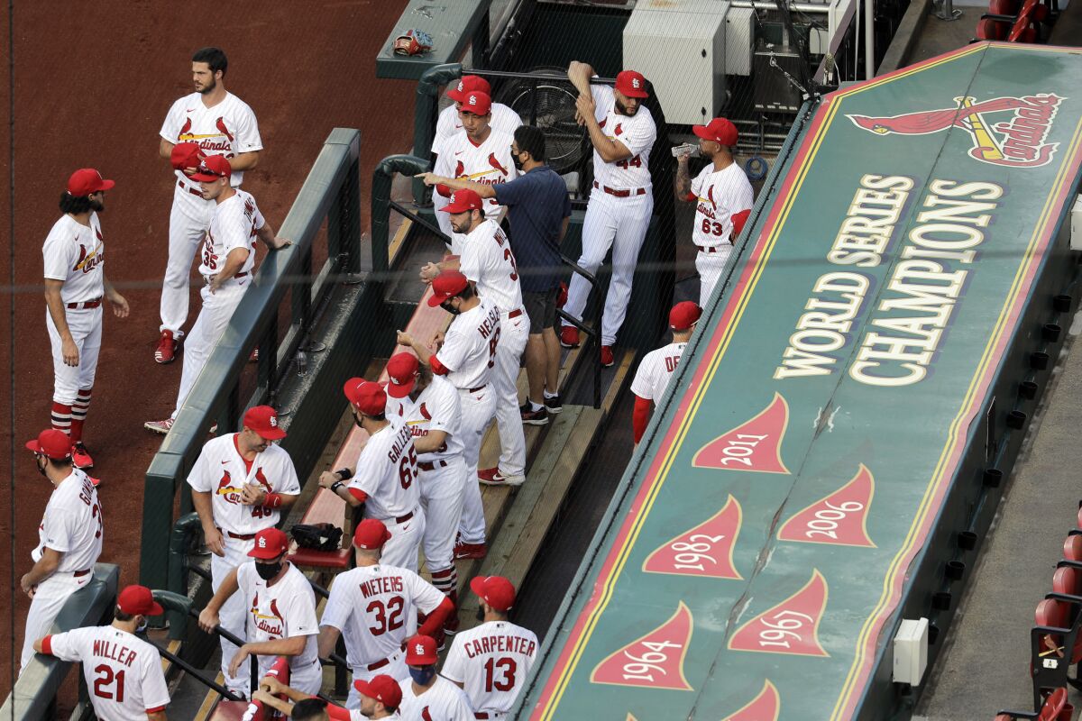 FILE - In this July 24, 2020, file photo, members of the St. Louis Cardinals wait to be introduced before the start of a baseball game against the Pittsburgh Pirates in St. Louis. The Cardinals 4-game series against the Detroit Tigers was postponed Monday, Aug. 3, 2020, after more Cardinals players and staff staffers test positive for COVD-19. The series was to have been played in Detroit from Tuesday through Thursday. (AP Photo/Jeff Roberson, File)