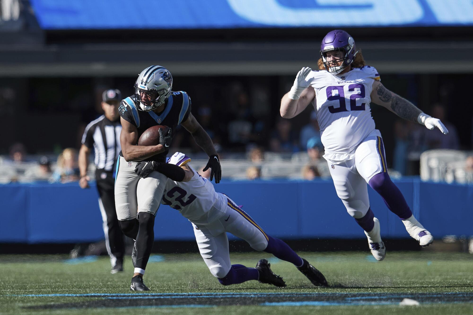 Panthers' DJ Moore tries to avoid the tackle attempt of Minnesota Vikings' Harrison Smith and James Lynch.