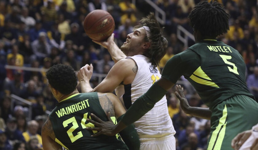 West Virginia forward Nathan Adrian (11) takes a shot while being defended by Baylor guard Ishmail Wainright (24) during the second half on Tuesday.
