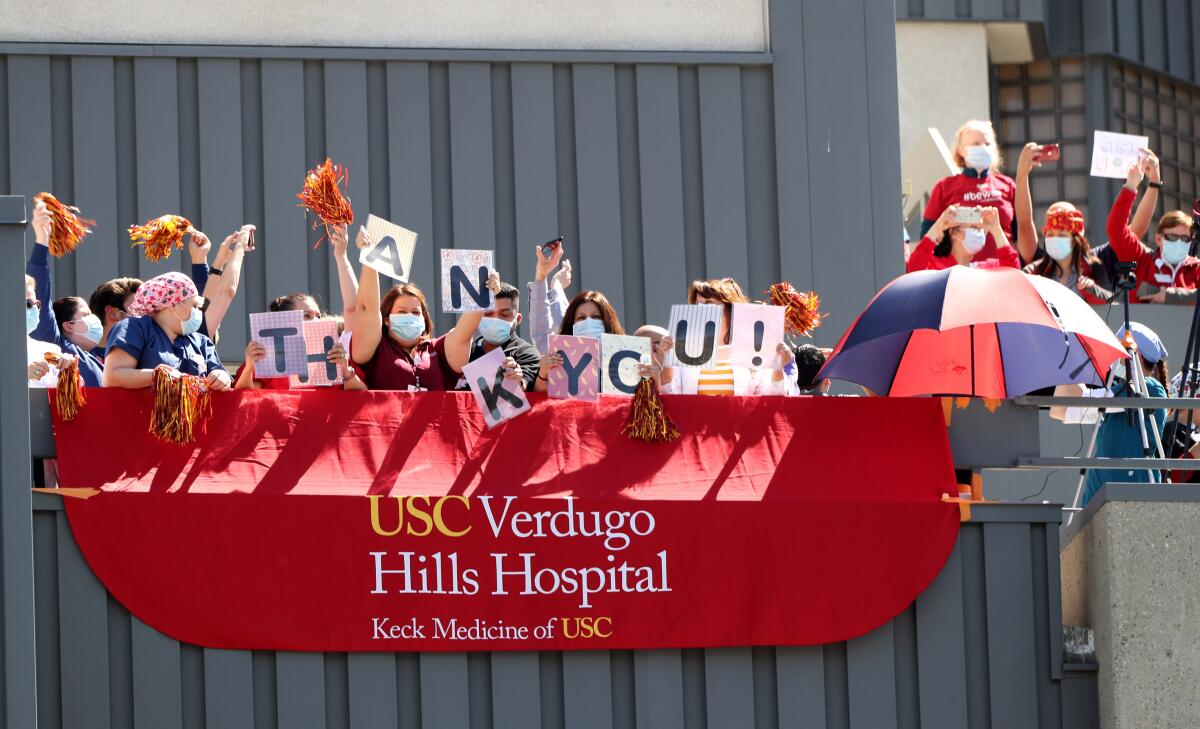 Healthcare workers at USC Verdugo Hills Hospital show their thanks for police officers and firefighters who came out to honor them on Wednesday, April 15, as they deal with the coronavirus pandemic. 