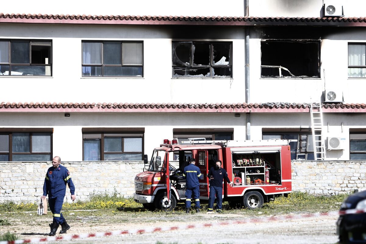 Firefighters stand in front of burnt hospital rooms after a fire in the northern port city of Thessaloniki, northern Greece, Wednesday, April 6, 2022. Firefighters were battling a blaze that broke out in a hospital where COVID-19 patients are being treated. (AP Photo/Giannis Papanikos)
