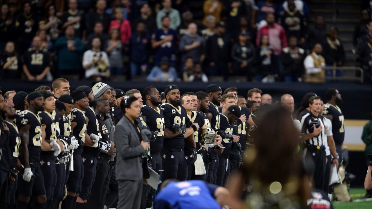 Members of the New Orleans Saints and their fans stand for the national anthem before a game against the Chicago Bears on Oct. 29 in New Orleans.