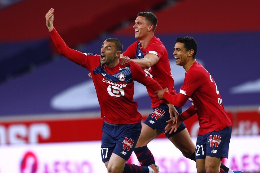 Lille's Burak Yilmaz, left, reacts after scoring during their French League One soccer match between Lille and Nice in Villeneuve d'Ascq, northern France, Saturday May 1, 2021. (AP Photo/Michel Spingler)