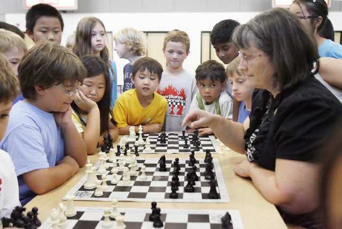 Max Totten, 11, sits across from chess master Ruth Haring with students from the Palm Crest Chess Club quietly watching at Palm Crest Elementary.