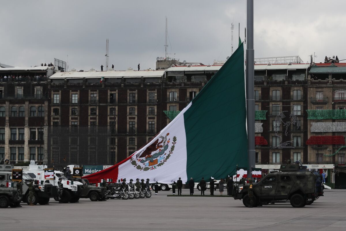Soldiers raise a Mexican national flag as part of its annual Independence Day military parade, on the Zocalo, the main plaza in Mexico City, Wednesday, Sept. 16, 2020. Mexicans celebrated their Independence Day without big public ceremonies for the first time in 153 years Tuesday night due to restrictions on public gatherings caused by the coronavirus pandemic. (AP Photo/Marco Ugarte)