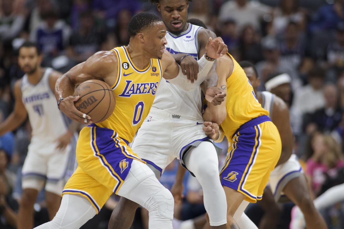 The Lakers' Russell Westbrook tries to drive past the Kings' Davion Mitchell on Oct. 14, 2022.