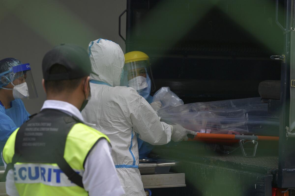 A medical staff load an unidentified body of the person who was killed by a gunman at a military base in Kuching, Sarawak, Malaysia, Friday, Aug. 13, 2021. A Malaysian air force official went on a shooting rampage Friday, killing a few colleagues before turning the gun on himself, police said. (AP Photo/Mohmad Nahari B Naha)