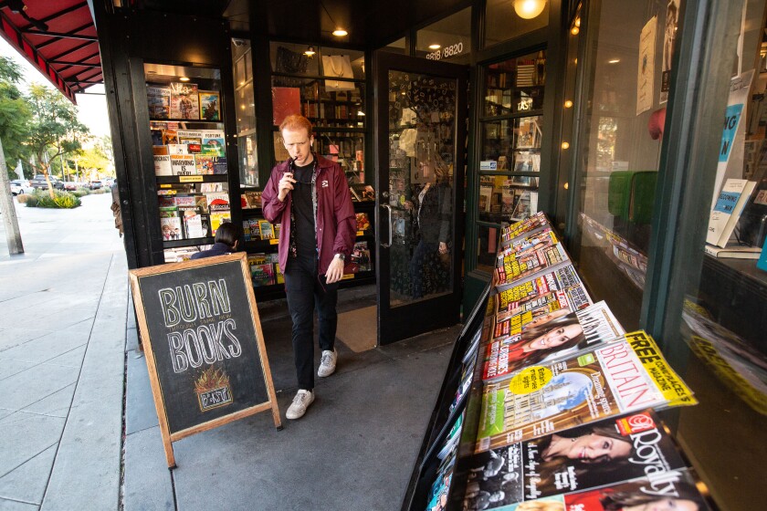 A man walks out of Book Soup. 