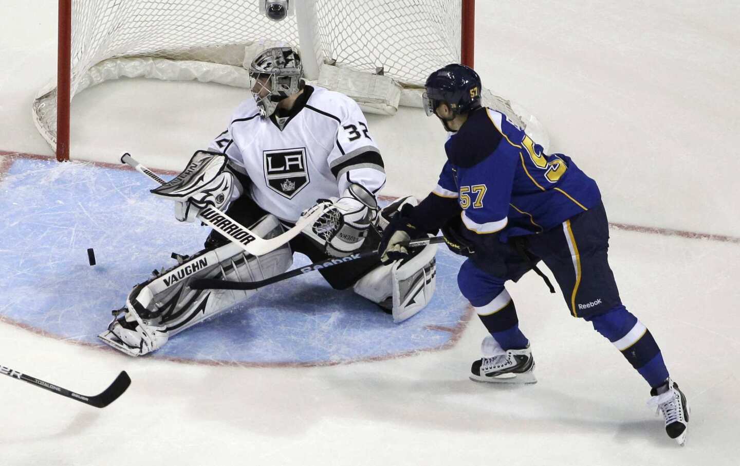 Kings goaltender Jonathan Quick and Blues winger David Perron watch the puck roll through the crease in the first period in Game 2 of their Western Conference semifinal playoff series on Monday night in St. Louis.