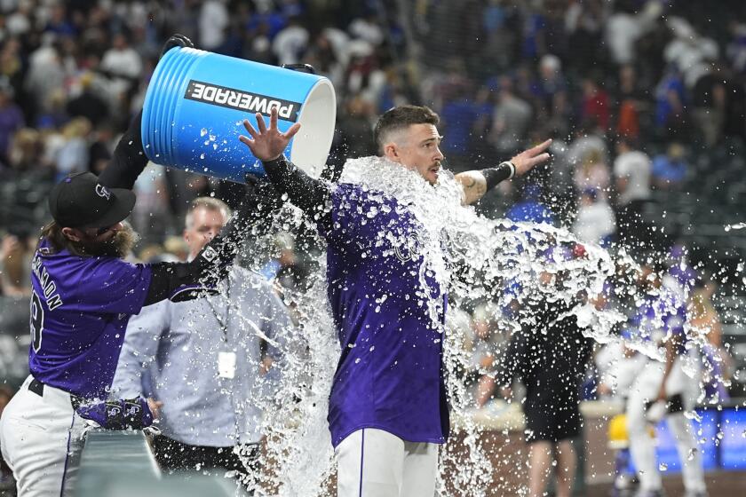 Colorado Rockies' Charlie Blackmon, left, douses Brenton Doyle after his walkoff RBI sacrifice fly to defeat the Los Angeles Dodgers 7-6 in a baseball game Wednesday, June 19, 2024, in Denver. (AP Photo/David Zalubowski)