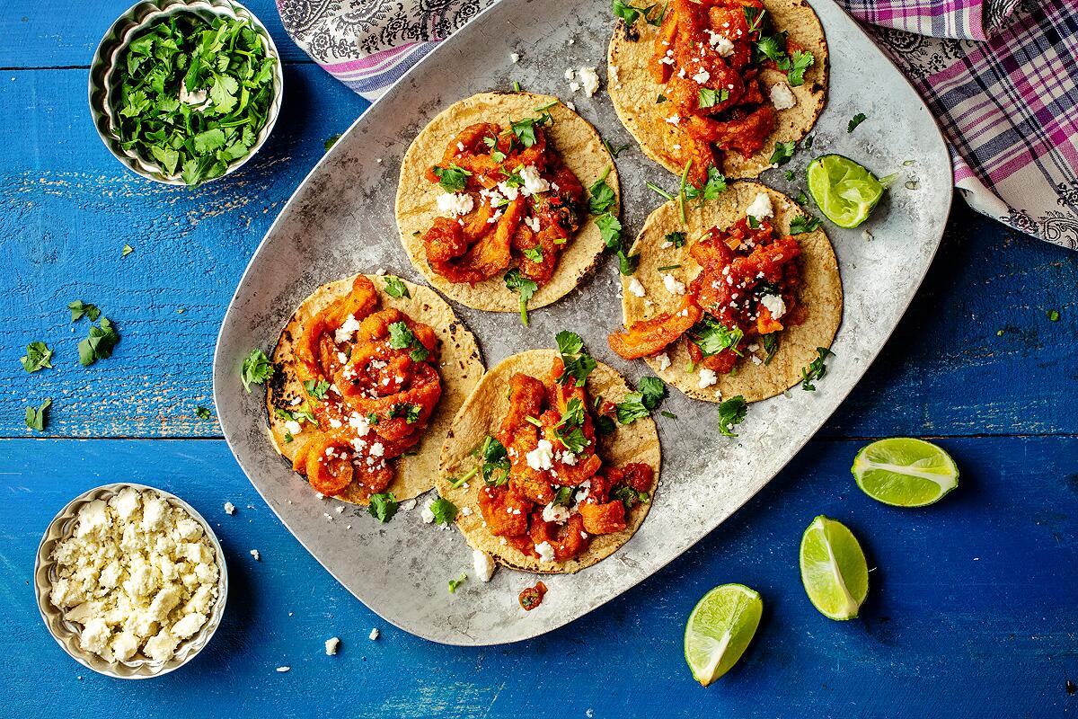 A taco platter of Mexican style pork rinds in a red chile sauce.