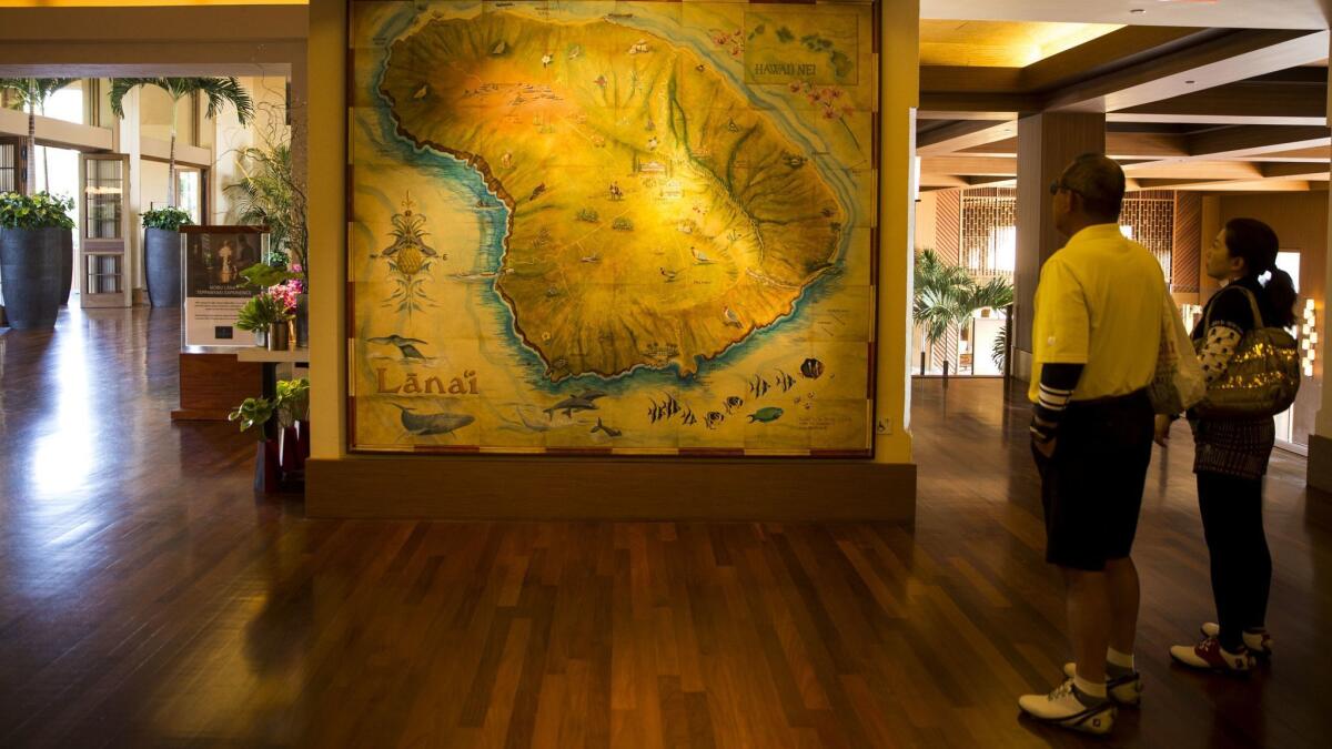 Visitors peruse a map of the the Hawaiian island at Four Seasons Lanai.