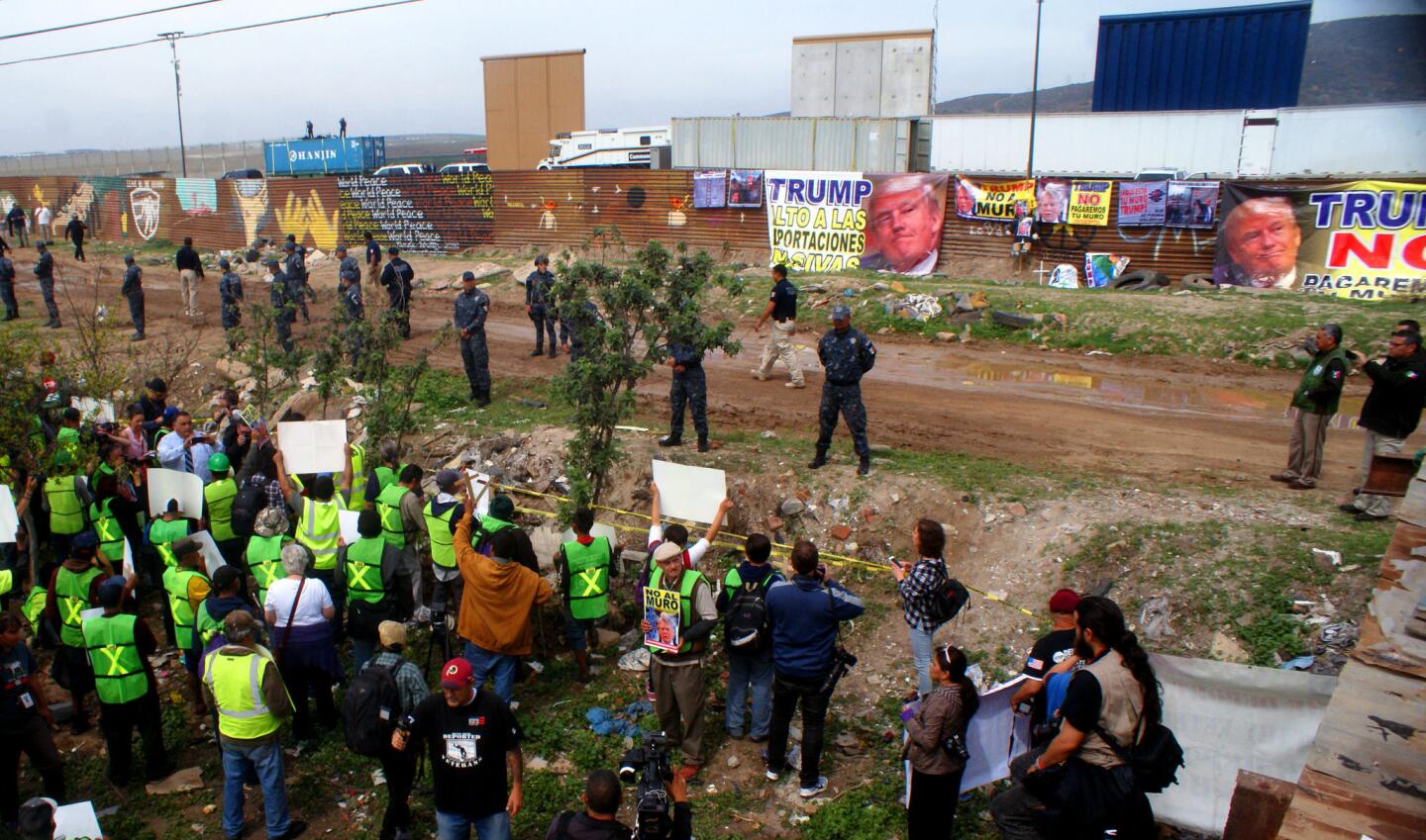 Un grupo de mexicanos se manifiesta junto a la frontera que delimita a México con territorio norteamericano en el punto de Las Torres, en Tijuana, cerca de donde construyeron los prototipos que revisño el presidente Trump.