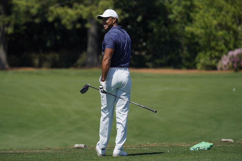 Tiger Woods waits to hit on the driving range during a practice round for the Masters golf tournament