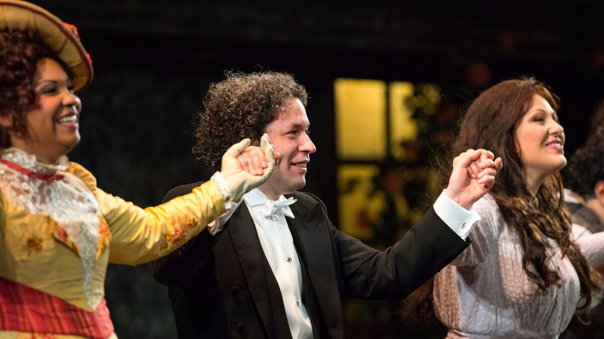 Gustavo Dudamel, center, takes a curtain call with Janai Brugger, left, and Nino Machaidze following their performance of Puccini's "La Boheme" at the Dorothy Chandler Pavilion.