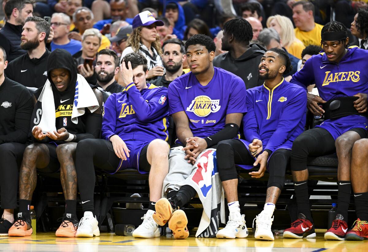 Lakers players sit on the bench watching the Warriors dominate Game 2 of their playoff series.