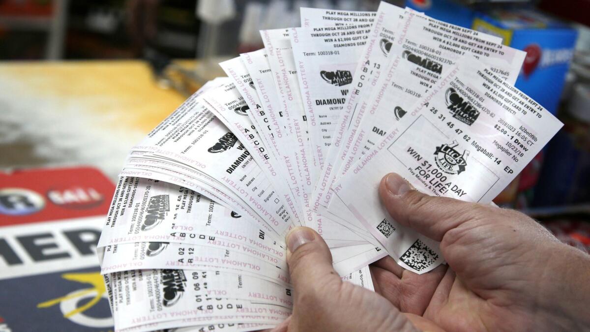 A customer holds $200 worth of Mega Millions tickets in Oklahoma City on Oct. 23.