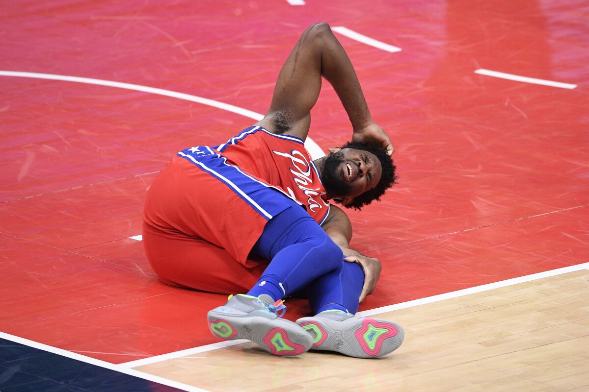 Philadelphia 76ers center Joel Embiid lay on the court after suffering an injury March 12, 2021, in Washington.