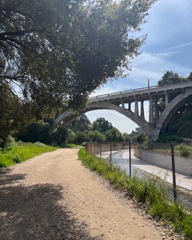 The dirt Lower Arroyo Seco Trail, with a bridge in the background.