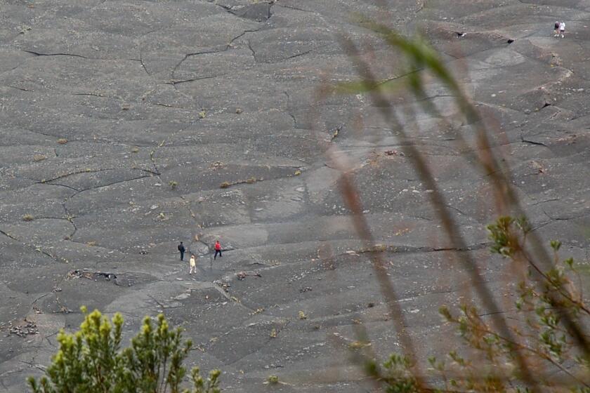 Tiny to the eye, these hikers are on the Kilauea Iki Trail, inside a caldera that's part of Hawaii Volcanoes National Park on the Big Island of Hawaii.