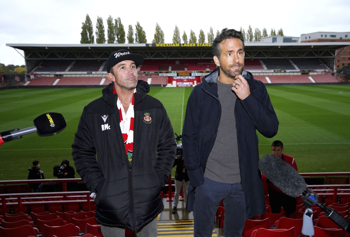 FILE - Wrexham co-chairmen Rob McElhenney, left, and Ryan Reynolds during a press conference at the Racecourse Ground, Wrexham, Wales, on Oct. 28, 2021. Soccer sensation Wrexham AFC is coming to America. The fifth-tier Welsh side, which has become a global fan favorite since Hollywood stars Reynolds and McElhenney bought it and then launched a documentary series, "Welcome to Wrexham," will play Manchester United in a friendly on July 25, 2023, at 35,000-seat Snapdragon Stadium in San Diego. (Peter Byrne/PA via AP, File)