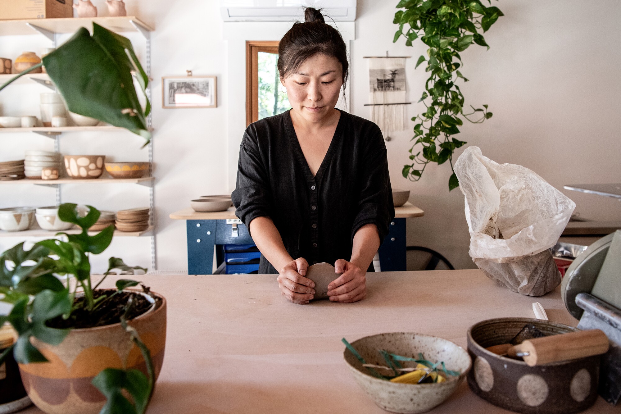A woman using her hands to shape clay