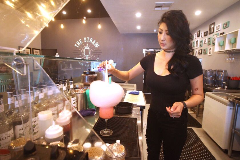 Caroline Nguyen prepares a modern specialty milkshake crowned with cotton candy at The Straw in Costa Mesa.