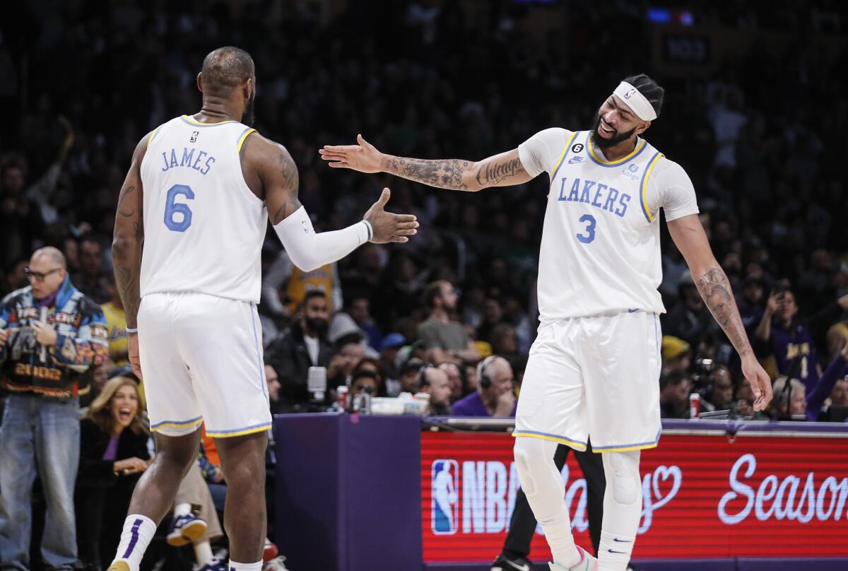 Anthony Davis and LeBron James reach out their hands in celebration.
