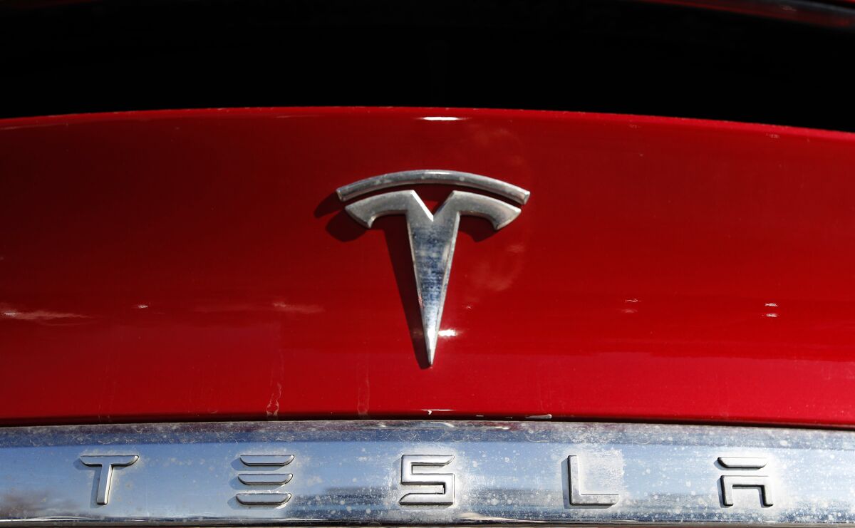 FILE - The Tesla company logo sits on an unsold 2020 Model X at a Tesla dealership in Littleton, Colo., on Feb. 2, 2020. Tesla has issued a recall that will automatically send a software update fixing a safety problem in its electric vehicles. The recall on Tuesday, Nov. 2, 2021, apparently heads off a looming confrontation with U.S. safety regulators. (AP Photo/David Zalubowski, File)
