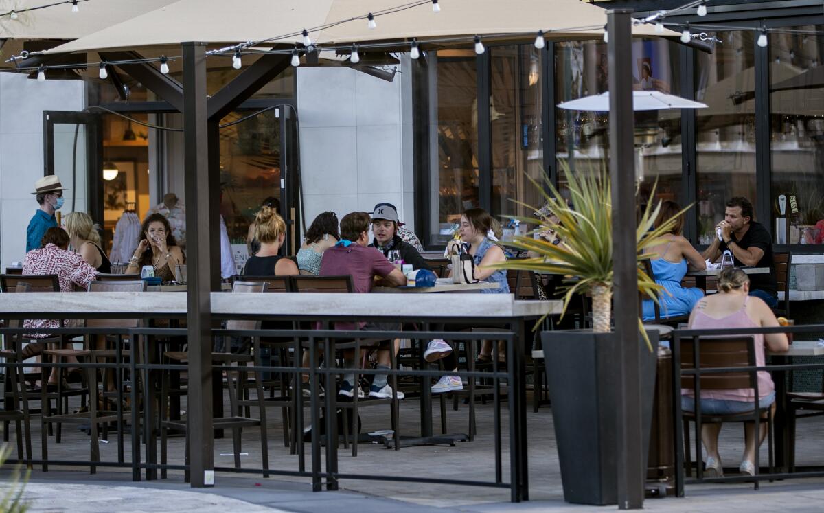 Unmasked customers sit on an outdoor patio 