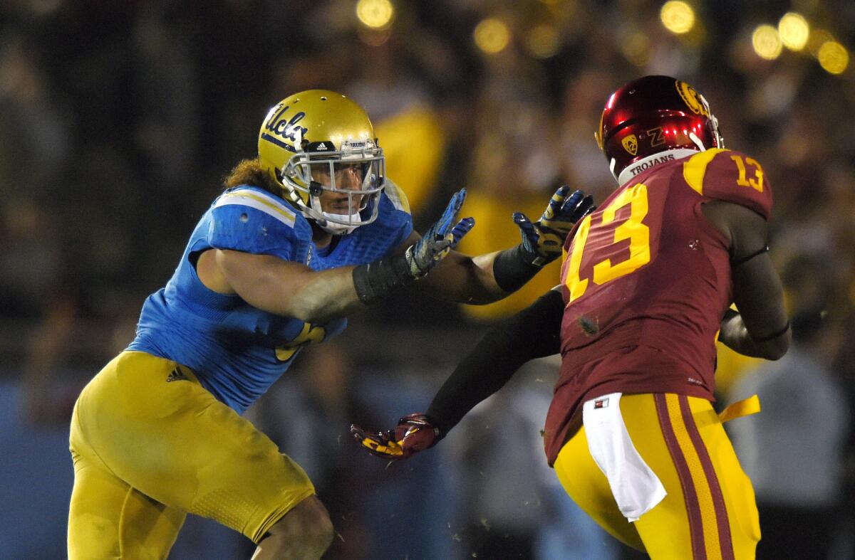 UCLA linebacker Eric Kendricks, left, moves in on Southern California tight end Bryce Dixon at the Rose Bowl on Saturday.