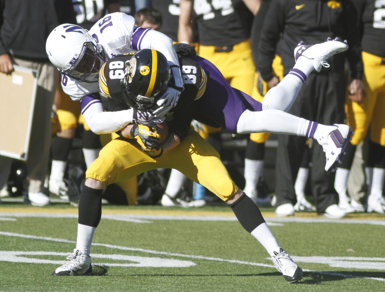 Iowa wide receiver Matt VandeBerg is tackled by Northwestern safety Godwin Igwebuike in the first quarter.