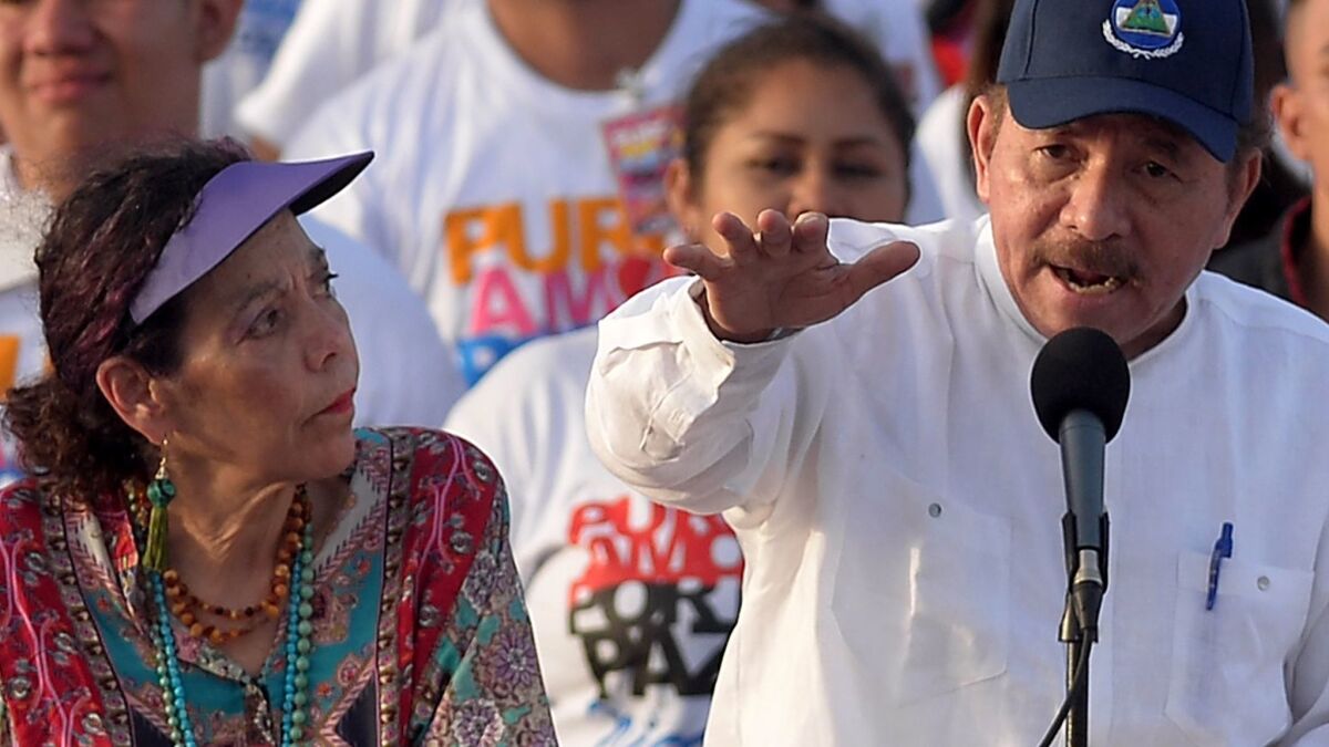 Nicaraguan President Daniel Ortega delivers a speech next to his wife and Vice President Rosario Murillo during the commemoration of the 39th anniversary of the Sandinista revolution at La Fe square in Managua on July 19, 2018.