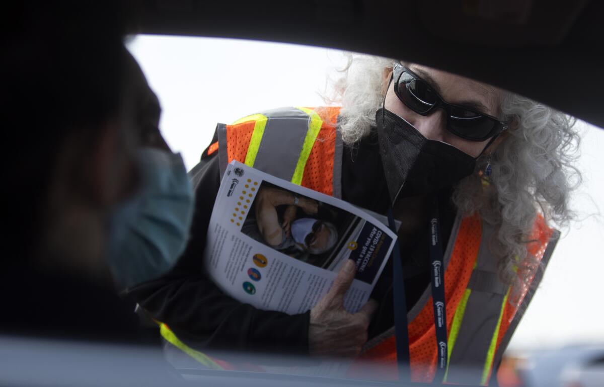 Barbara Ferrer looks inside a car window.