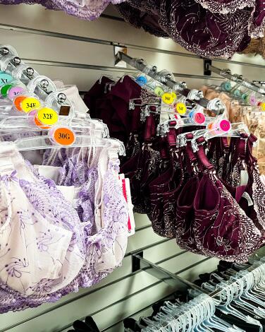 Bras in a variety of hard-to-find sizes, including 38G and 32F, on rows of hangers. 
