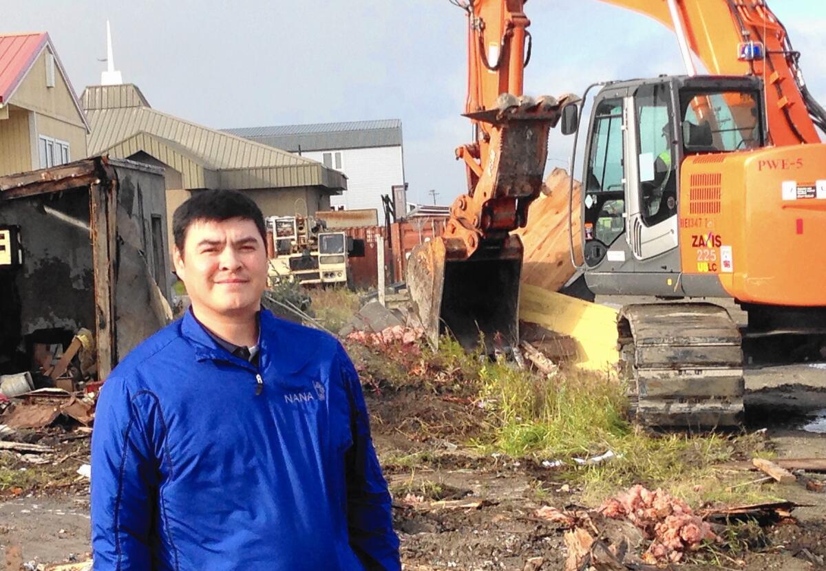 Damon Schaeffer stands by as a city crew demolishes a decrepit building in Kotzebue, Alaska. He postponed his annual moose hunt to help the city prepare for President Obama's visit.