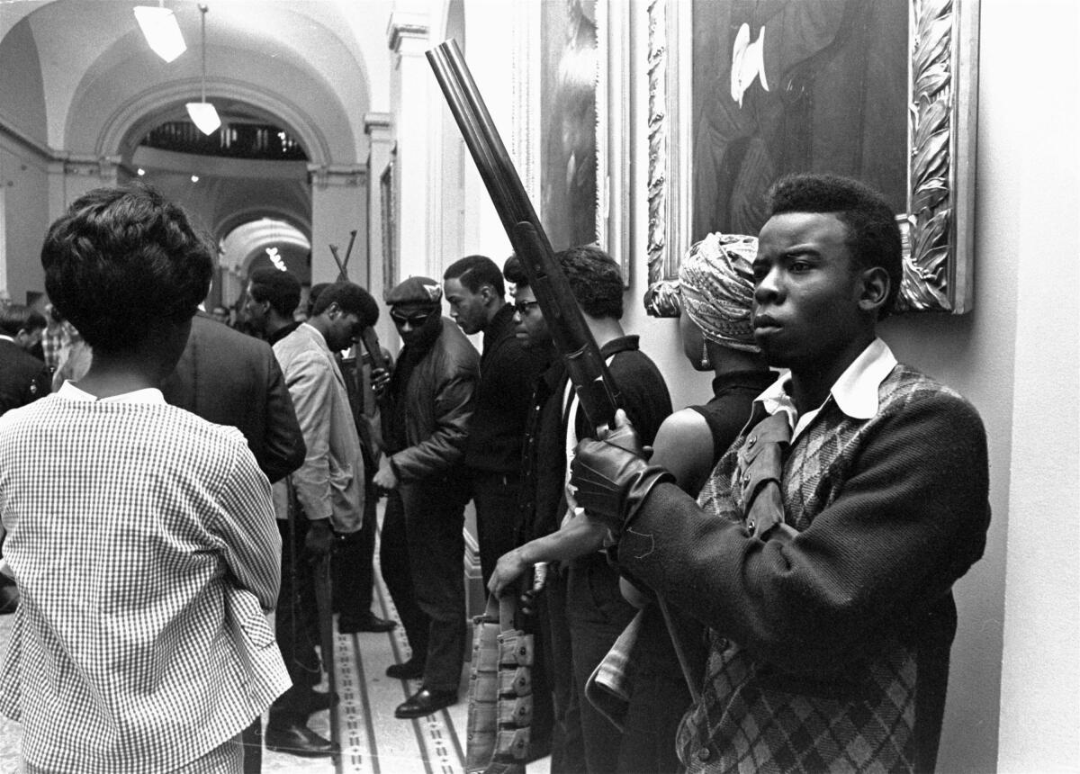 Armed members of the Black Panthers Party stand in the corridor of the Capitol in Sacramento, Calif.