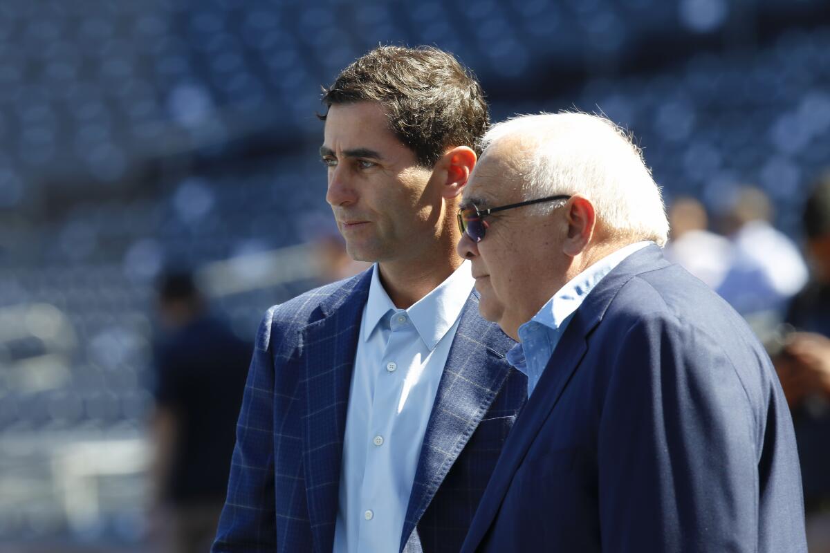 Padres GM A.J. Preller and Ron Fowler, Executive Chairman, watch players during batting practice.
