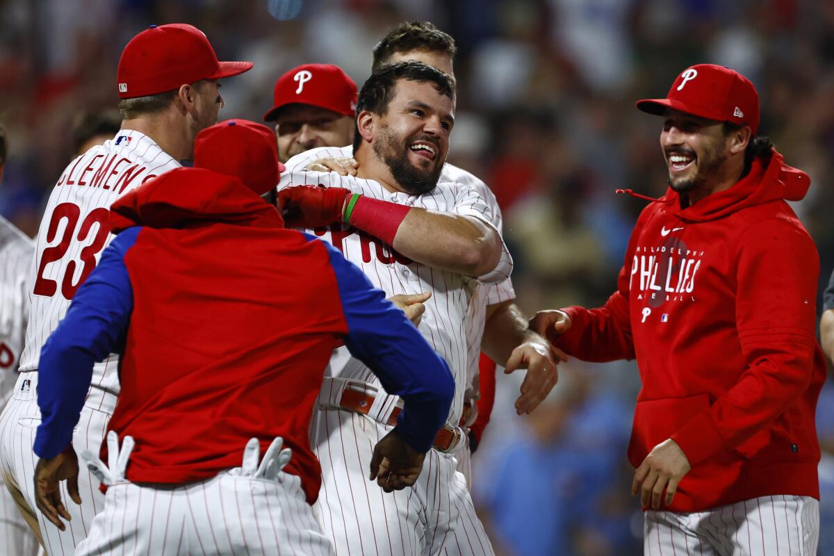 Kyle Schwarber, center, celebrates with his Philadelphia Phillies teammates after hitting a walk-off home run.