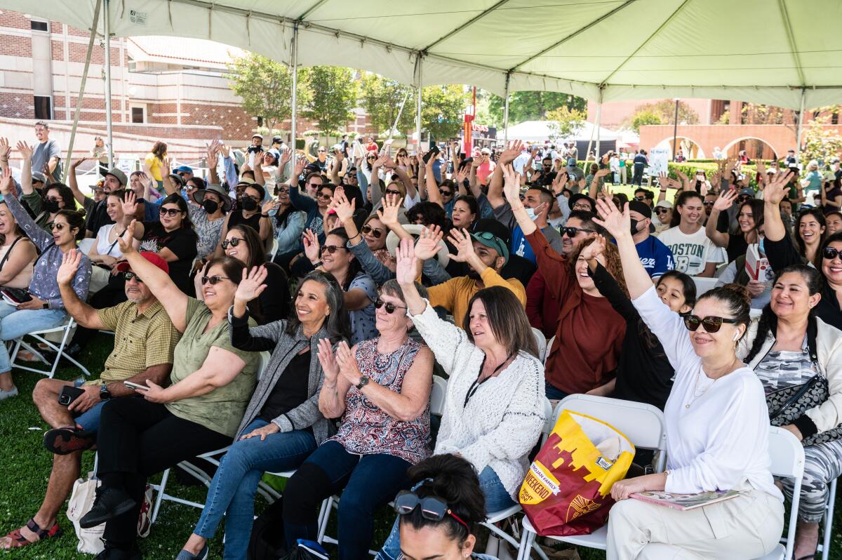 People cheer in a tent at a festival.