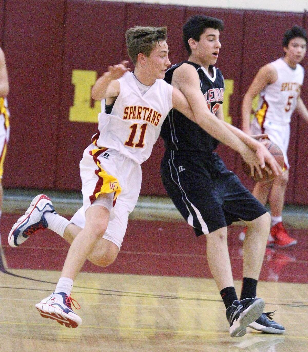 La Cañada's Grant Arthur commits a foul chasing the ball around Glendale's Raffi Jivalagian in the La Cañada Holiday Classic boys' basketball tournament on Tuesday.