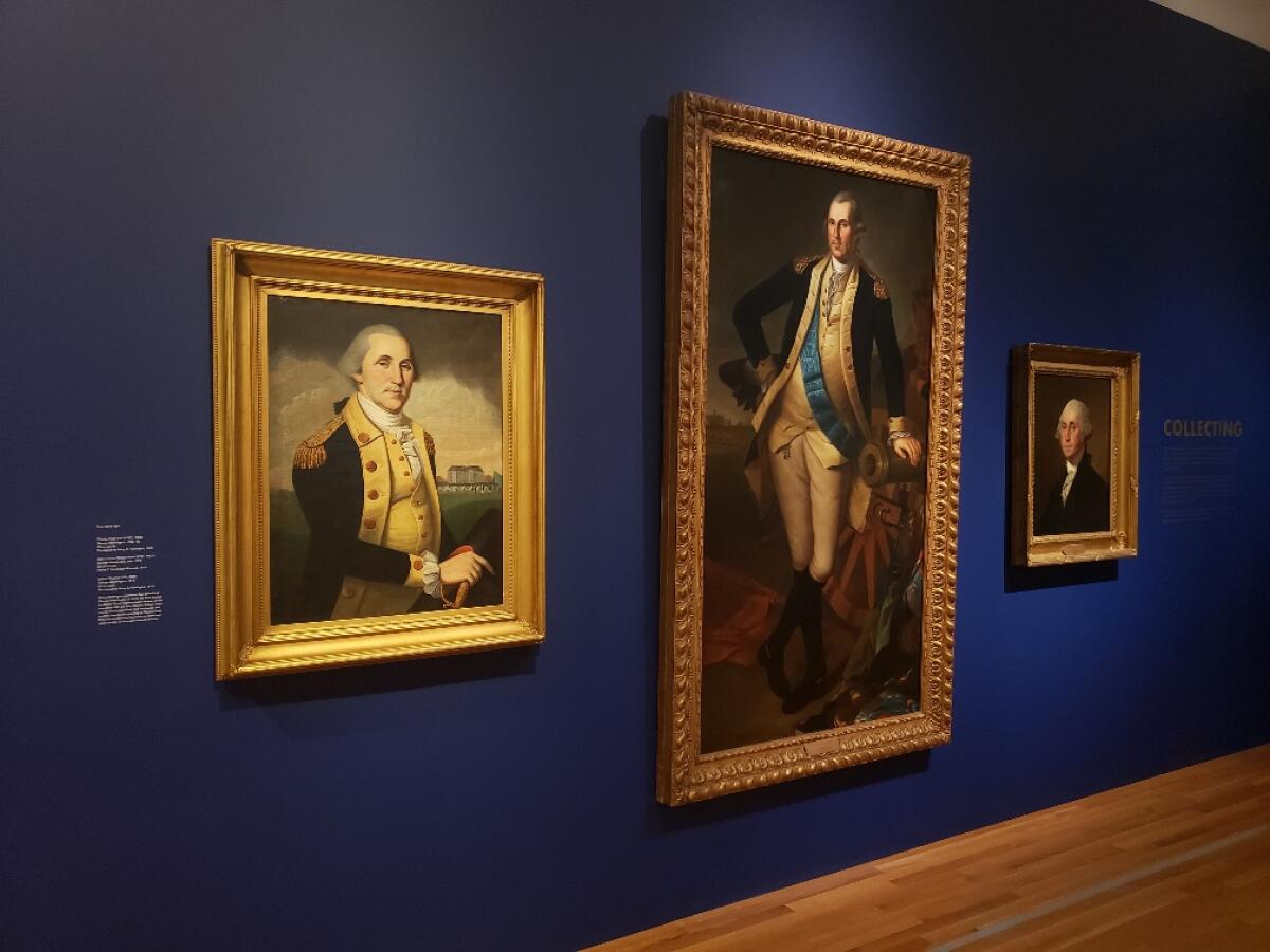 Three painted portraits in gold frames hung in a musuem