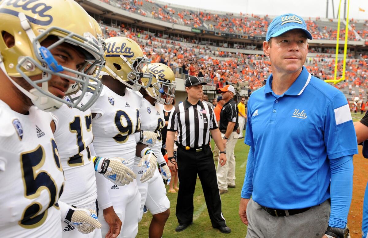 UCLA Coach Jim Mora stands in front of his Bruins team before Aug. 30 win over Virginia, 28-20.