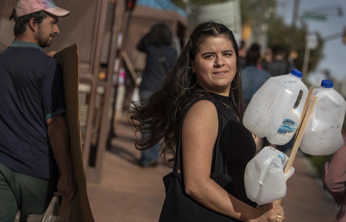 No More Deaths volunteer Zaachila Orozco-McCormick marches with empty water jugs following her sentencing for misdemeanor charges involving leaving aid in a restricted area of Cabeza Prieta National Wildlife Refuge.