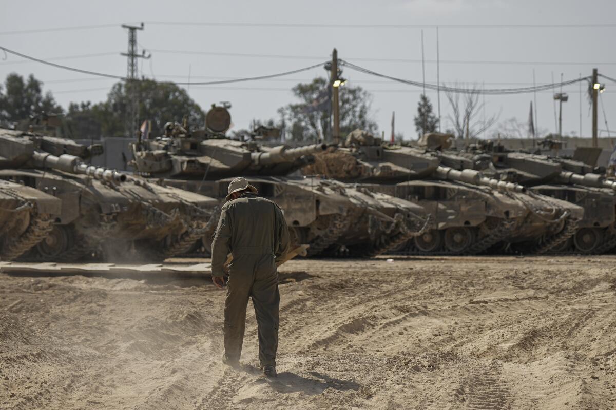 Israeli soldiers work on tanks at a staging ground near the border with the Gaza Strip on April 11.