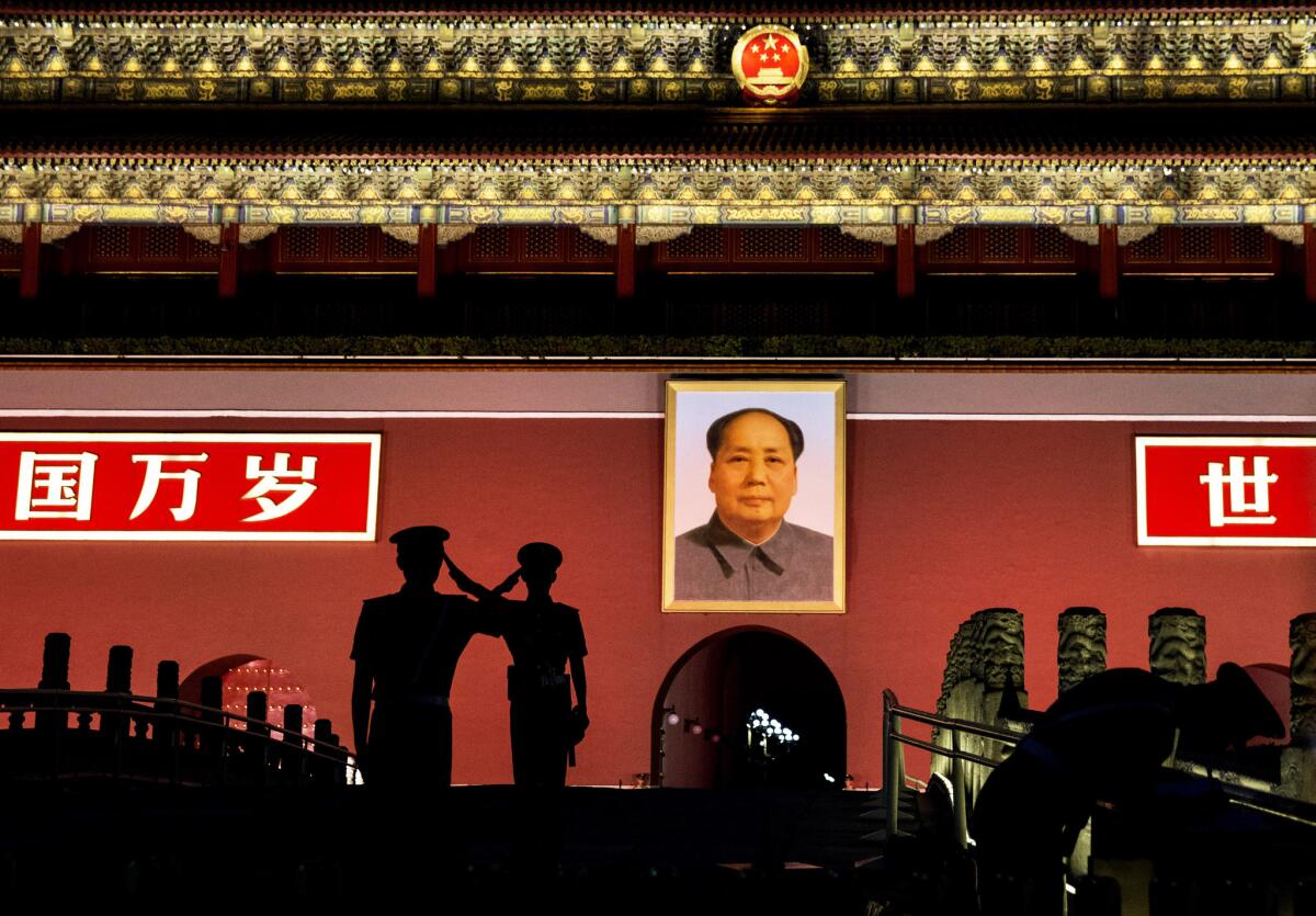 Chinese paramilitary police salute each other as they stand guard beneath a portrait of the late leader Mao Tse-tung in Tiananmen Square on Wednesday.