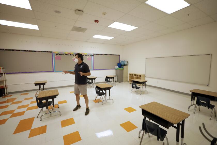 WALNUT PARK, CA - AUGUST 13: Xavier Reyes, founder of Alta Public Schools, shows the reduced size and increased spacing in classrooms at Academia Moderna in Walnut Park. The school will reopen with a staggered schedule and smaller class sizes. Photographed at Academia Moderna on Thursday, Aug. 13, 2020 in Walnut Park, CA. (Myung J. Chun / Los Angeles Times)