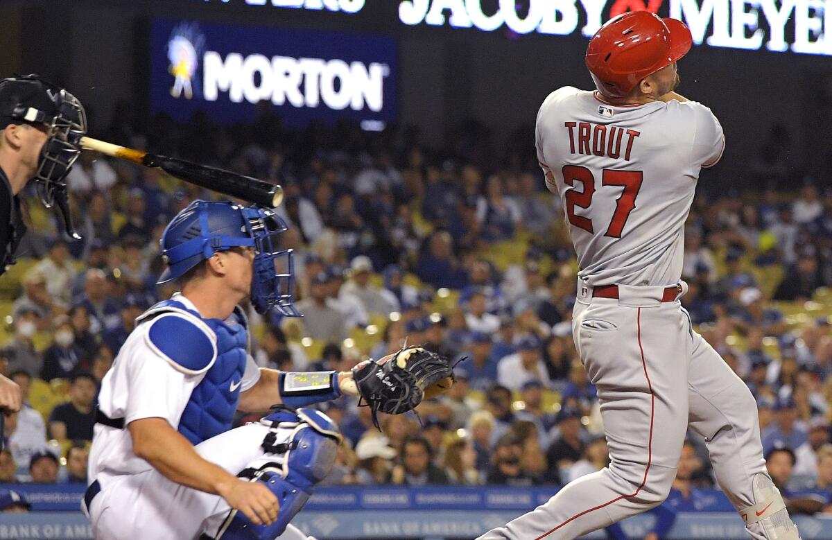 Home plate umpire Nate Tomlinson, left, is hit in the face with a broken bat after Los Angeles Angels' Mike Trout